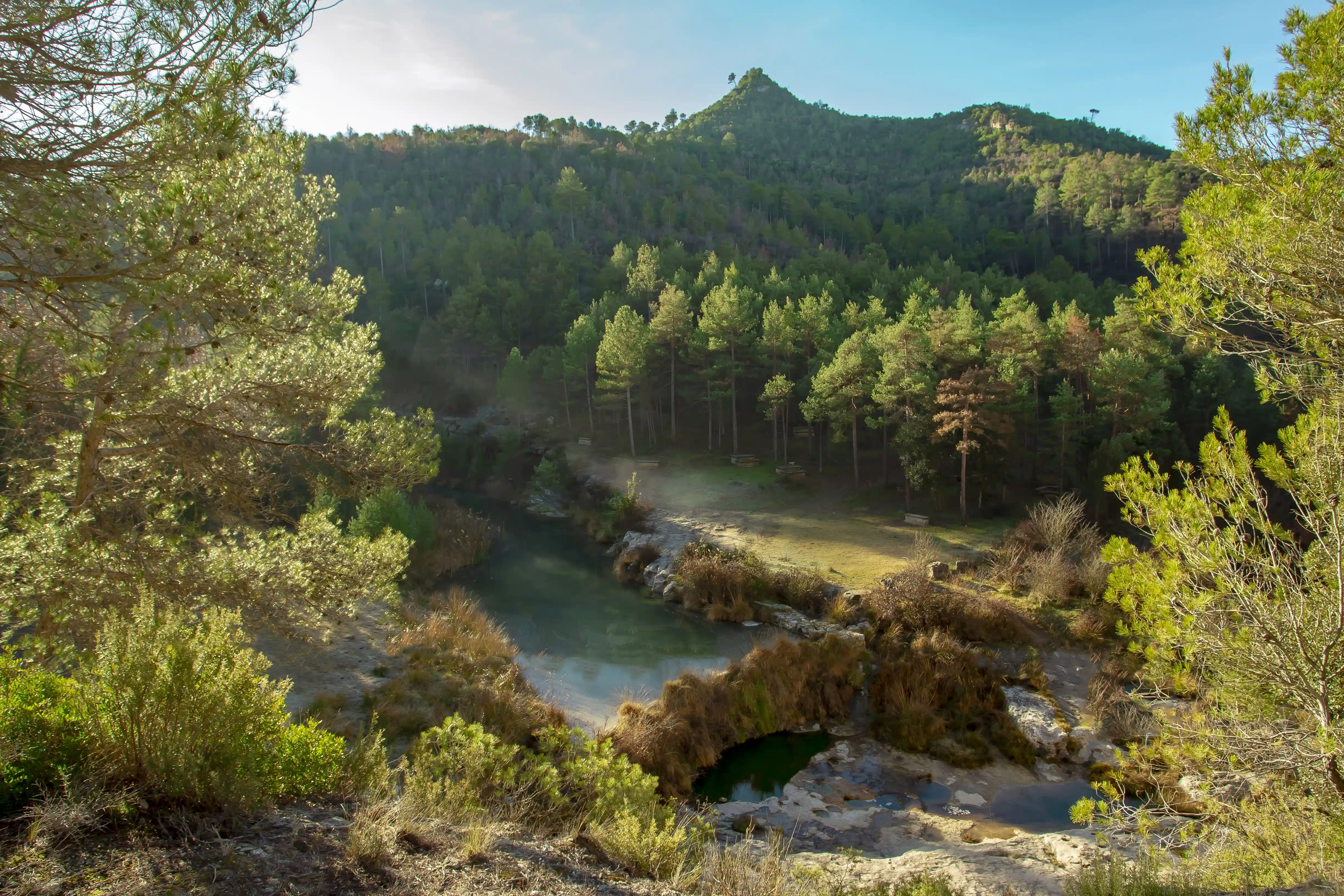Aerial view of the river winding through the forests around Mas Girbau